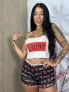 Modelo com baby doll Netflix — blusa branca com logotipo vermelho da Netflix e short preto com a mesma estampa
